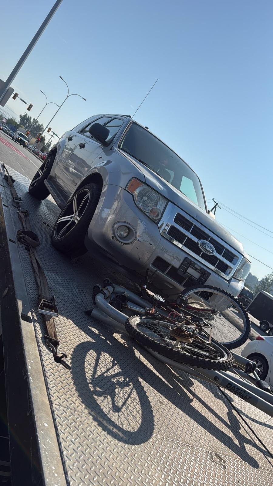 Dark-coloured car loaded onto a vehicle transport trailer