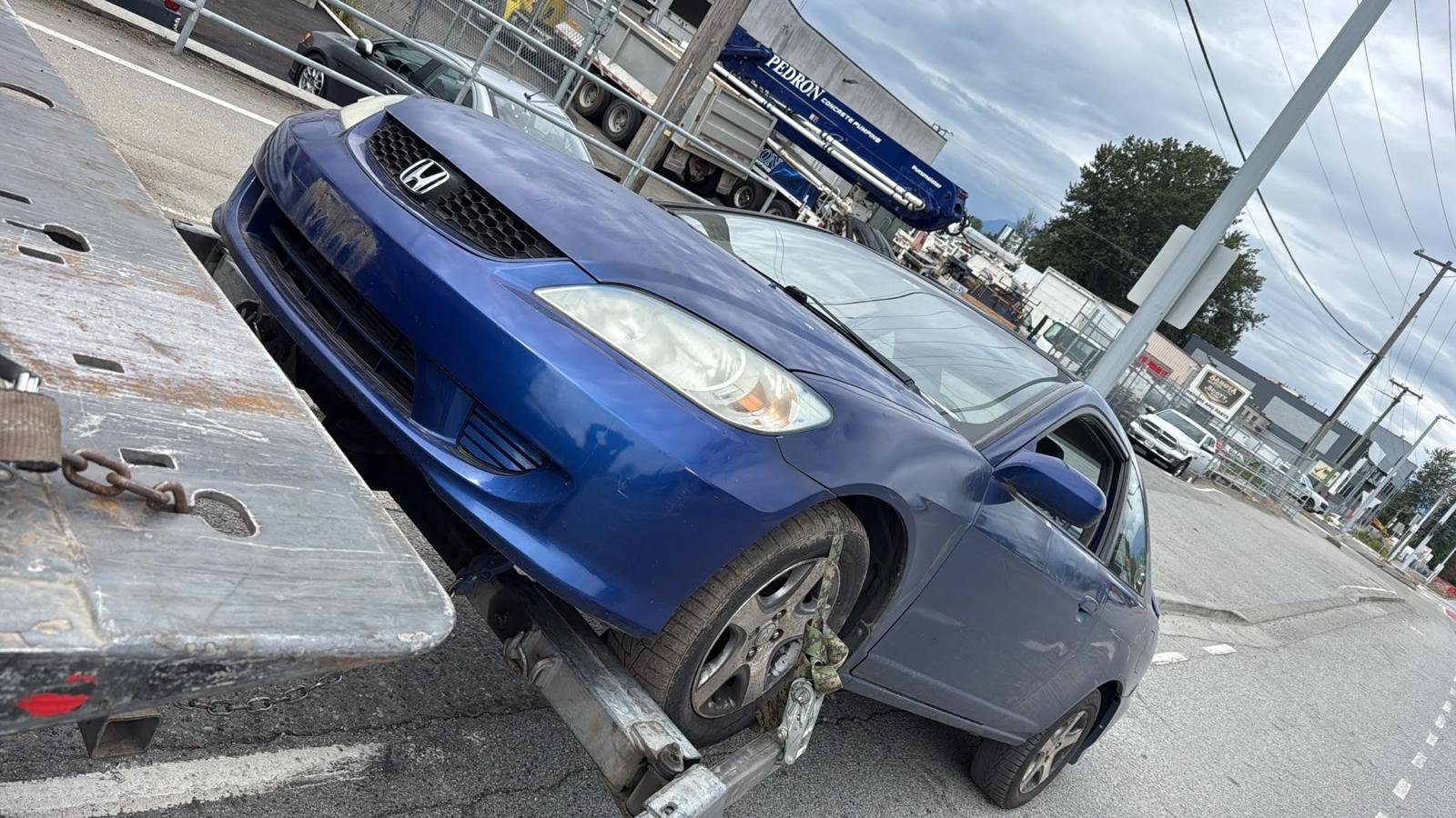 Blue Honda passenger car in a vehicle-recycling setting